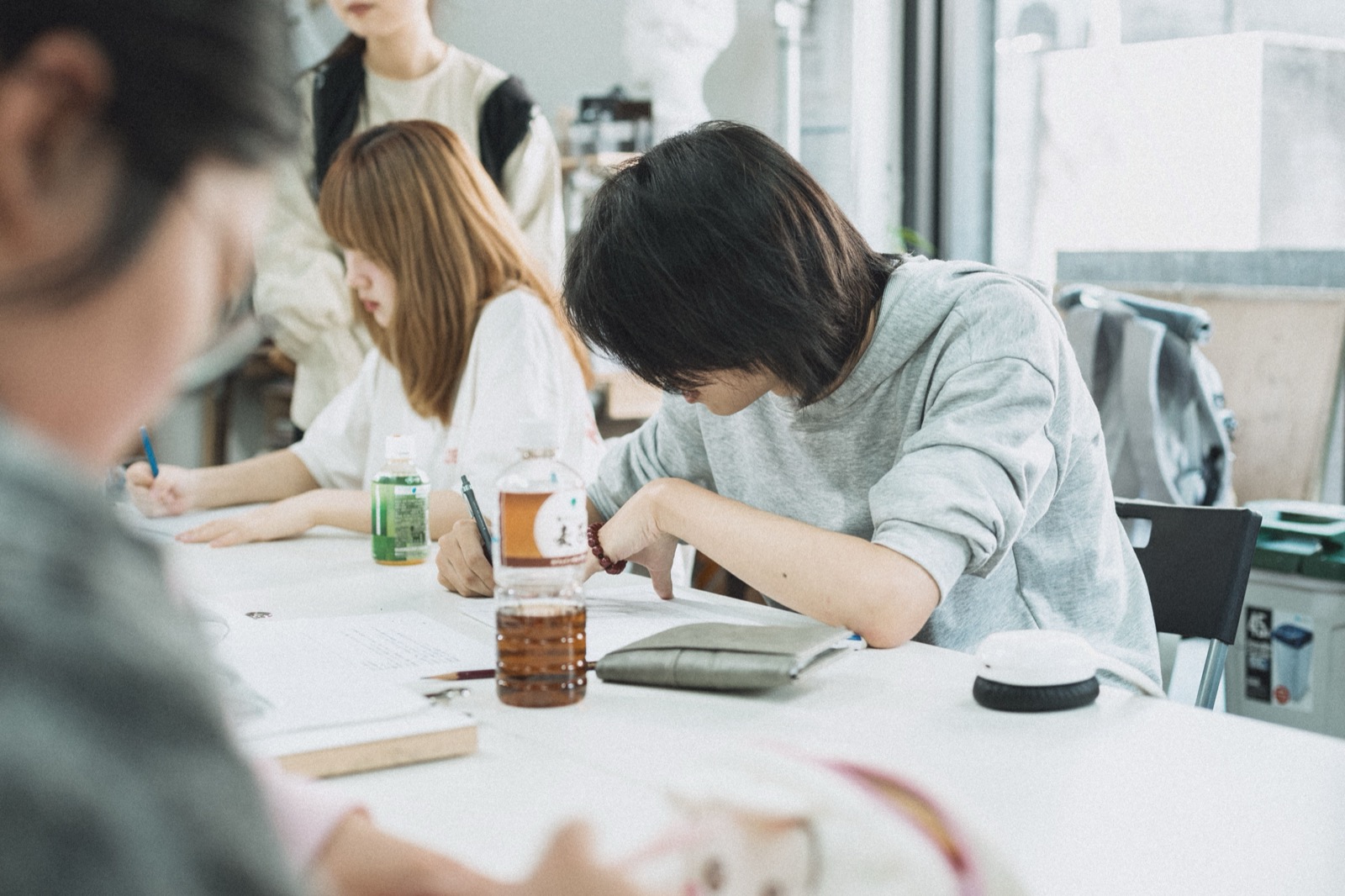 Étudiants japonais penchés sur leurs cahiers dans une salle de classe