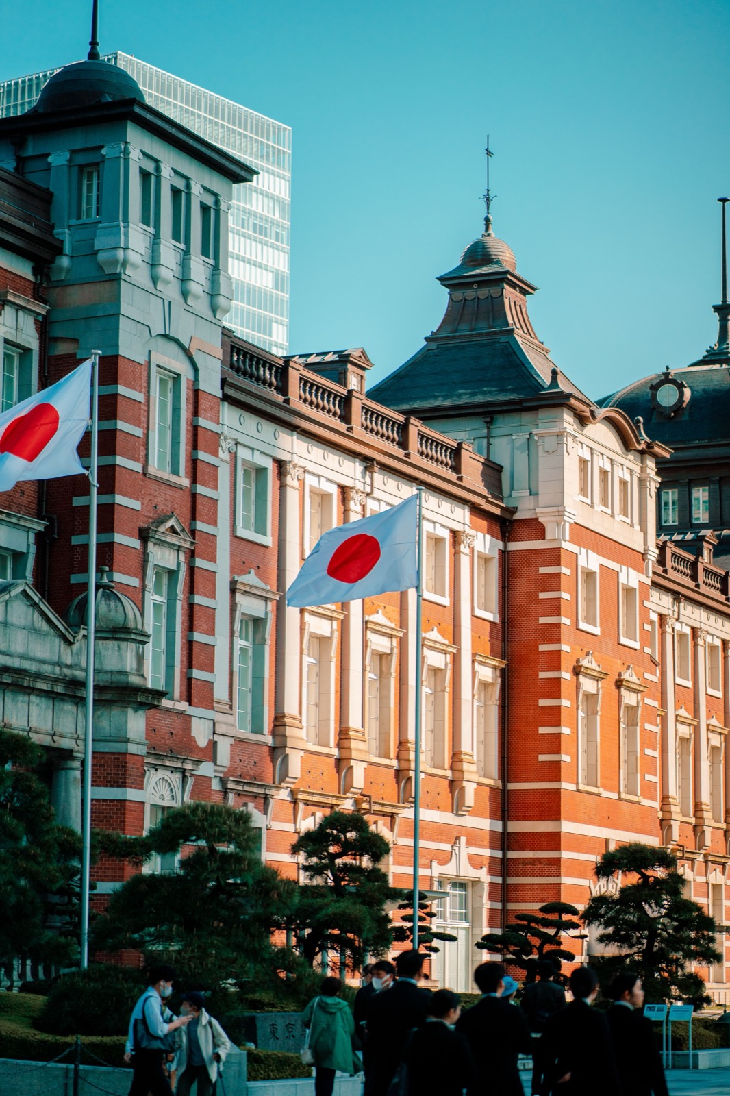 Employés de bureau japonais en costume devant la gare de Tokyo