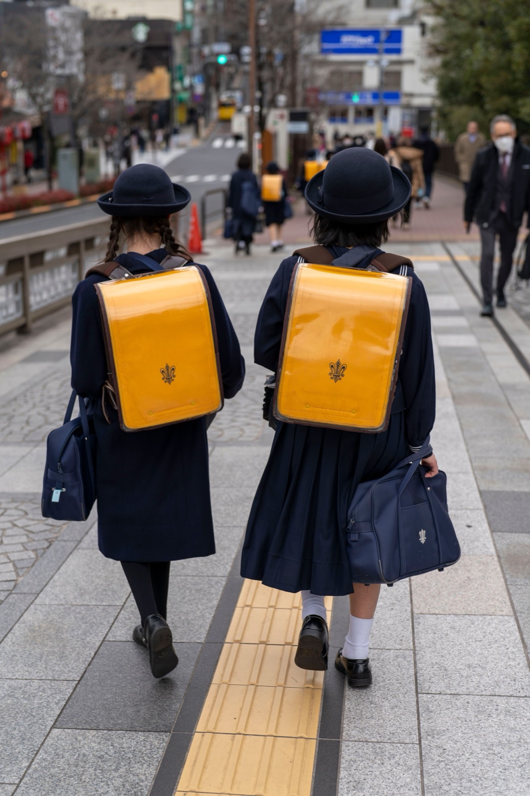 Deux écolières japonaises de dos, cartables sur le dos, marchant vers l'école